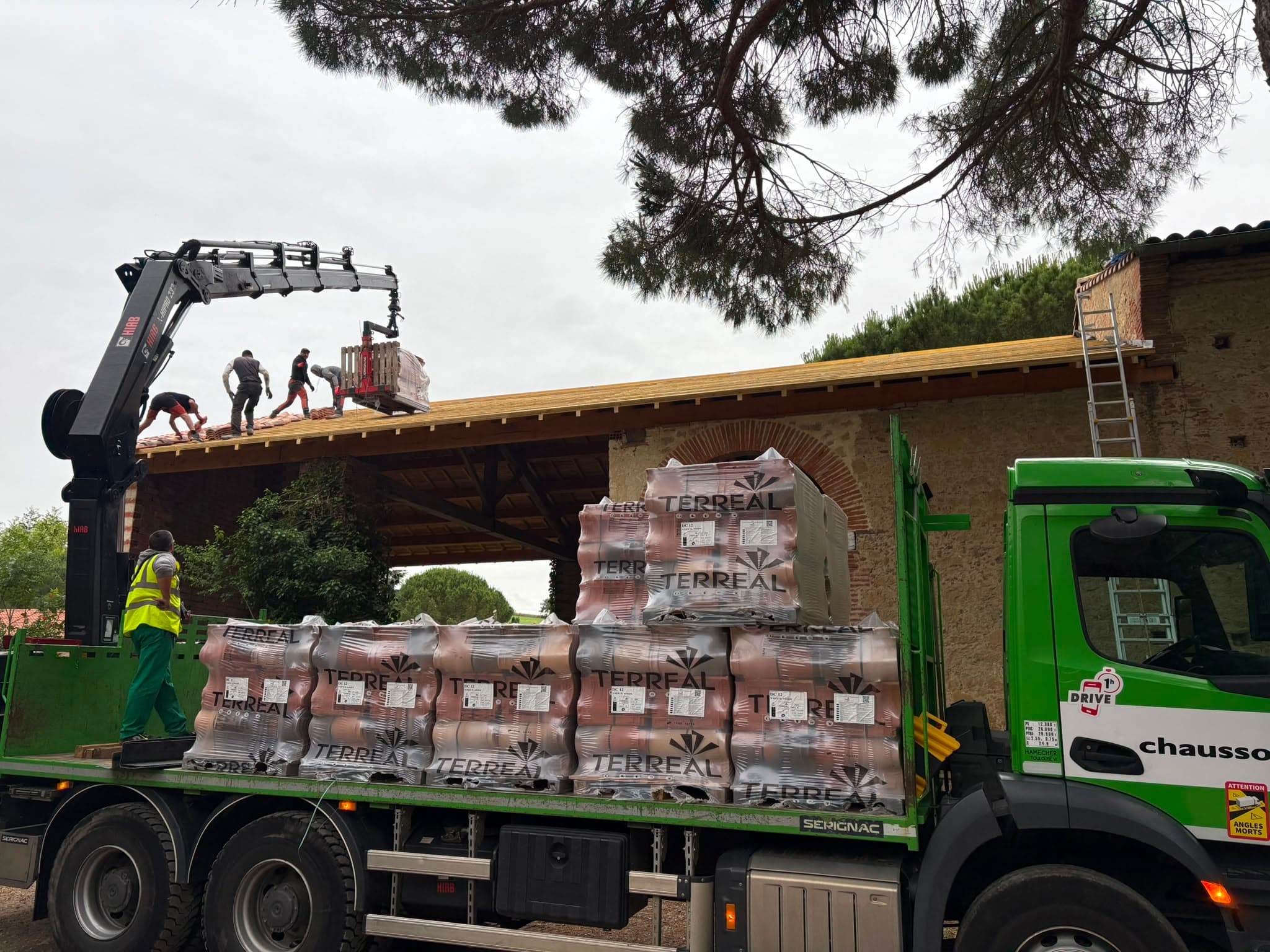 Livraison des tuiles sur une bâtisse en pierre
